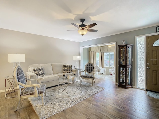 living room featuring ceiling fan, hardwood / wood-style flooring, and ornamental molding