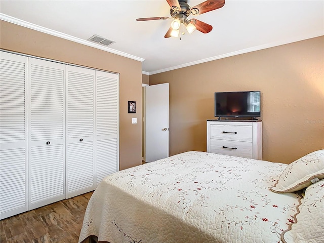 bedroom with a closet, ceiling fan, dark hardwood / wood-style floors, and crown molding