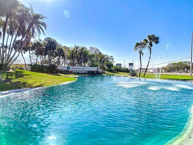 view of pool with a lawn