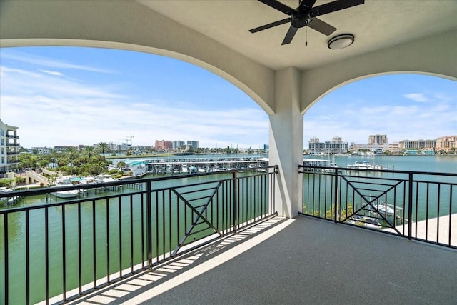 balcony with ceiling fan and a water view