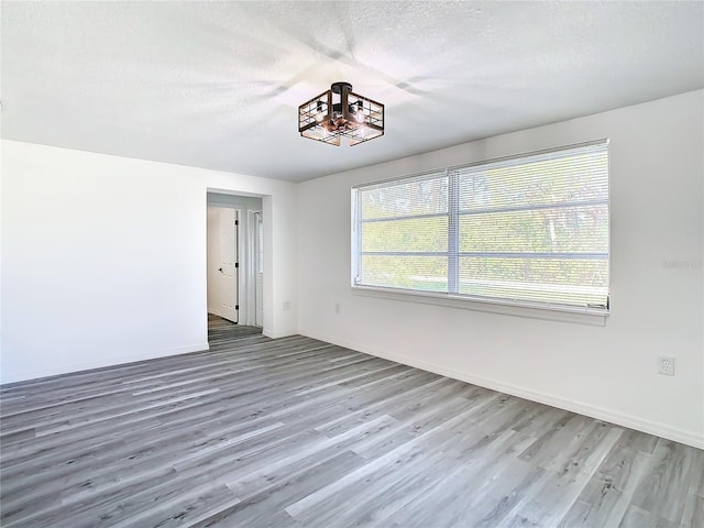 spare room with a textured ceiling and hardwood / wood-style floors