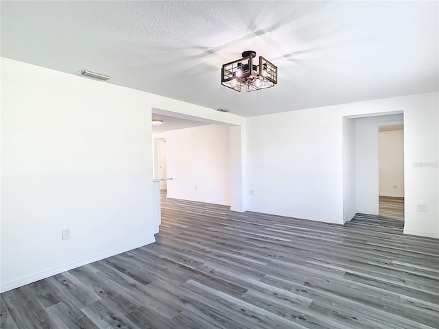 unfurnished room with a textured ceiling and hardwood / wood-style floors