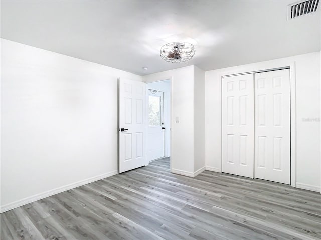 unfurnished bedroom with a closet and hardwood / wood-style floors