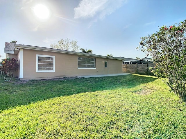 rear view of property featuring a lawn