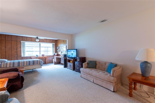 carpeted living room with wooden walls