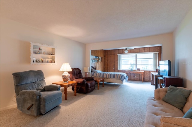 carpeted living room with wooden walls