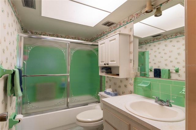 full bathroom with vanity, shower / bath combination with glass door, backsplash, and toilet