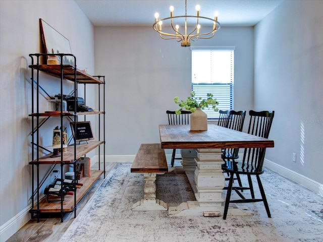 dining area with hardwood / wood-style floors and an inviting chandelier