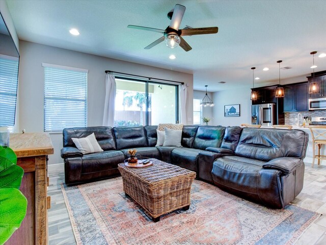 living room featuring light hardwood / wood-style flooring and ceiling fan