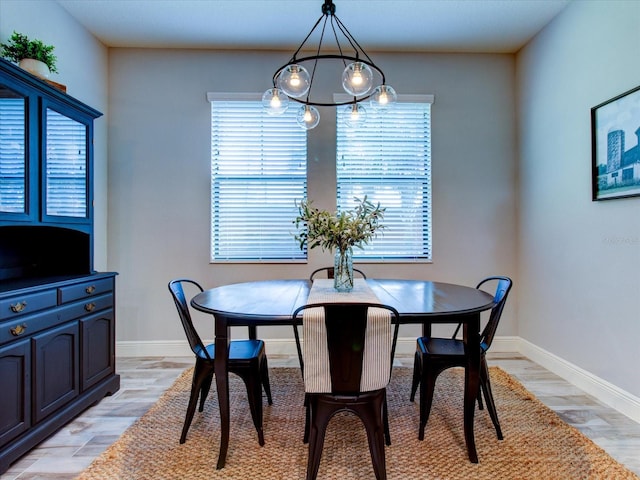 dining room with an inviting chandelier, a healthy amount of sunlight, and light wood-type flooring