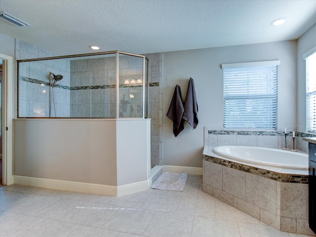 bathroom with tile patterned floors, a textured ceiling, and shower with separate bathtub