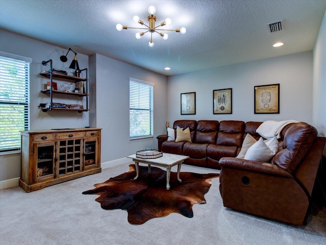 living room featuring a textured ceiling, light colored carpet, a wealth of natural light, and a notable chandelier