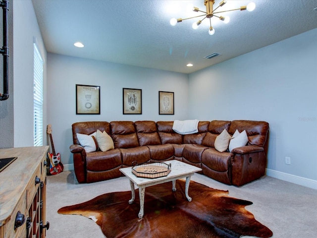 living room with a textured ceiling, light carpet, and an inviting chandelier