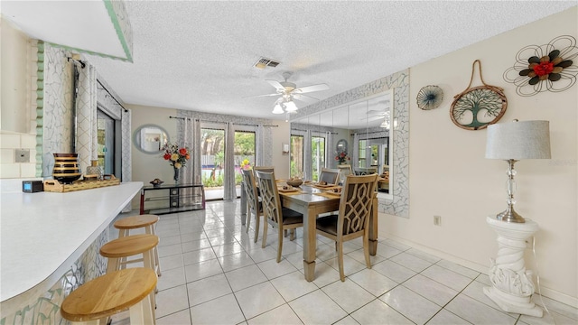 dining space with light tile floors, french doors, a textured ceiling, and ceiling fan