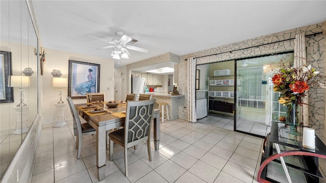 tiled dining room featuring ceiling fan and a textured ceiling