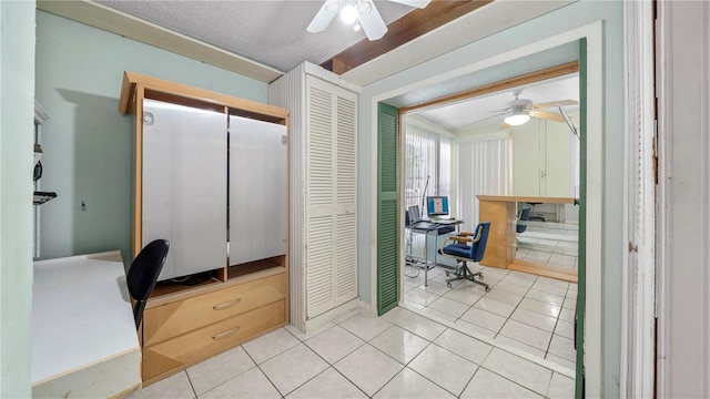 interior space with light tile floors, ceiling fan, and a textured ceiling