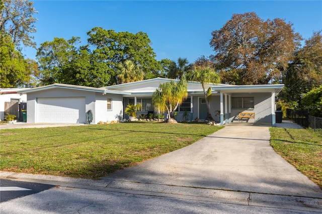 ranch-style house featuring a carport, a front yard, and a garage