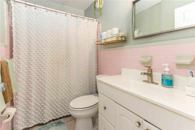 bathroom with tile patterned floors, toilet, a shower with curtain, vanity, and tile walls