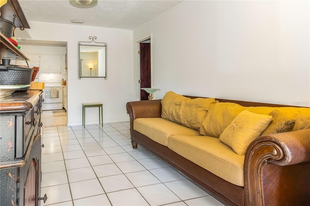 living room with a textured ceiling and light tile patterned flooring