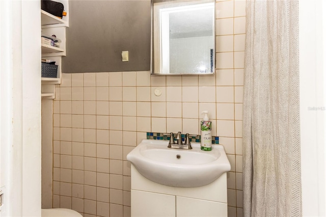 bathroom featuring tile walls, vanity, curtained shower, and toilet