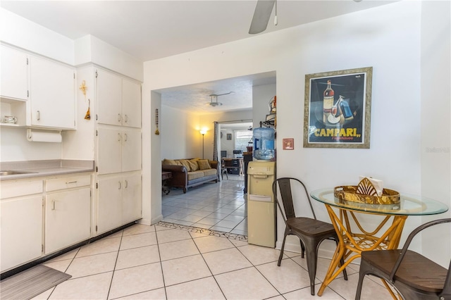 kitchen with sink, white cabinetry, ceiling fan, and light tile patterned floors