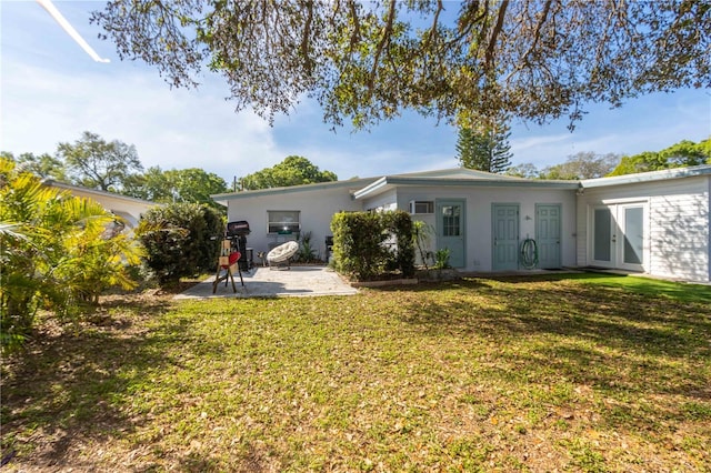 rear view of property featuring a patio and a lawn