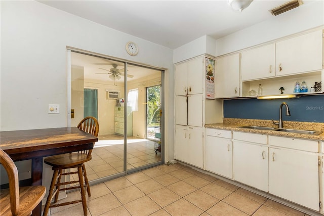 kitchen with sink, white cabinetry, light tile patterned floors, and ceiling fan