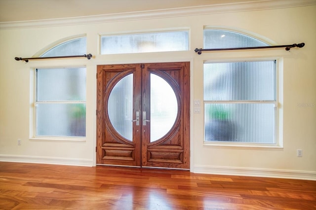 entrance foyer with crown molding, dark hardwood / wood-style floors, and french doors