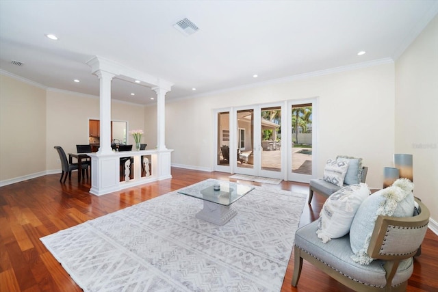 living room featuring crown molding, dark hardwood / wood-style floors, and ornate columns