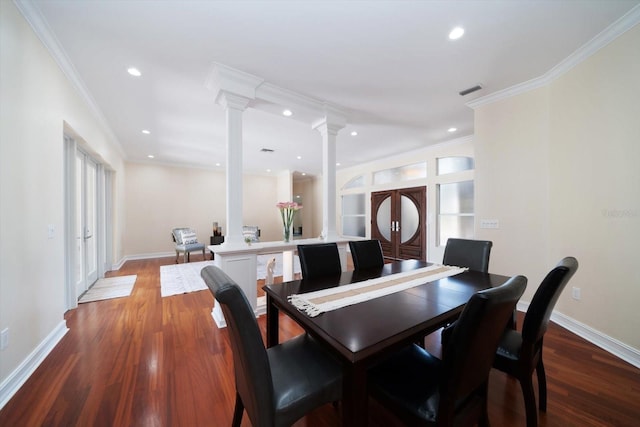 dining space featuring hardwood / wood-style floors, ornamental molding, and ornate columns