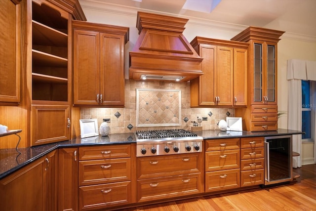 kitchen featuring light wood-type flooring, beverage cooler, dark stone counters, custom range hood, and gas cooktop