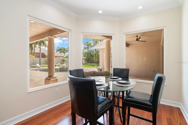 dining space featuring crown molding, ornate columns, and dark hardwood / wood-style flooring