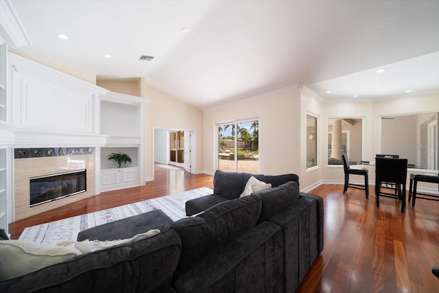 living room with ornamental molding, dark hardwood / wood-style floors, vaulted ceiling, and a fireplace