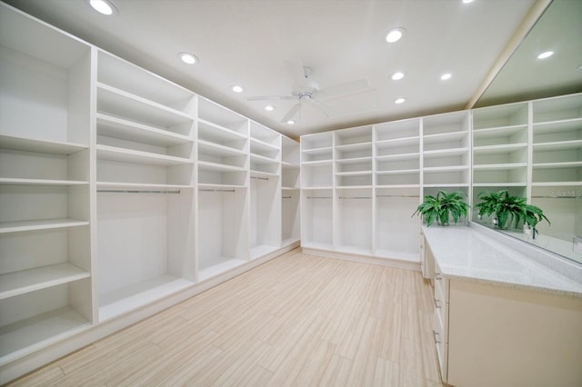 spacious closet featuring light hardwood / wood-style flooring and ceiling fan