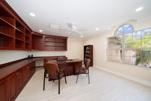 office space with ceiling fan, built in desk, and ornamental molding