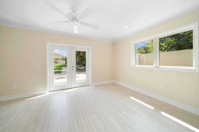 spare room featuring light hardwood / wood-style floors, ceiling fan, french doors, and a wealth of natural light