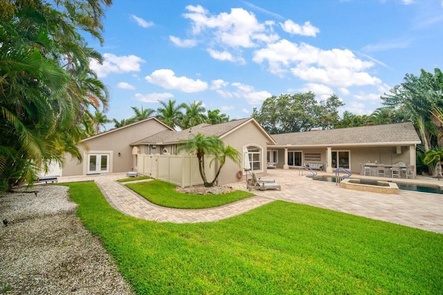 back of house featuring french doors, a fenced in pool, a lawn, and a patio area