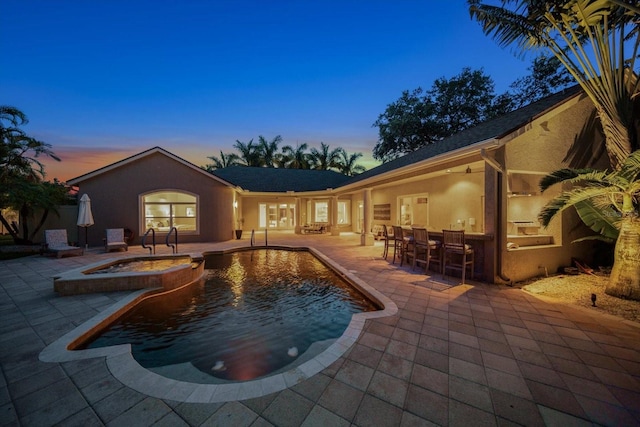 pool at dusk with a patio