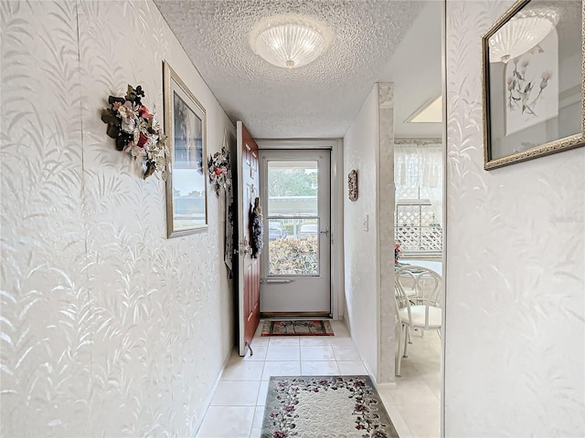 entryway with a textured ceiling and light tile flooring