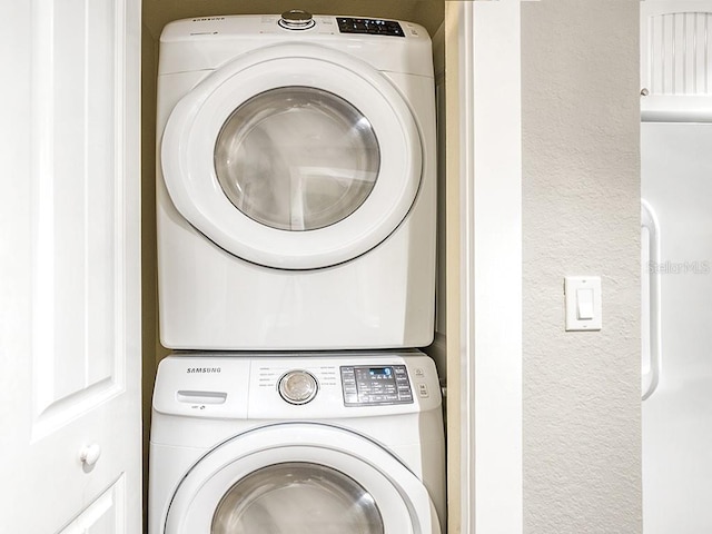 clothes washing area featuring stacked washing maching and dryer