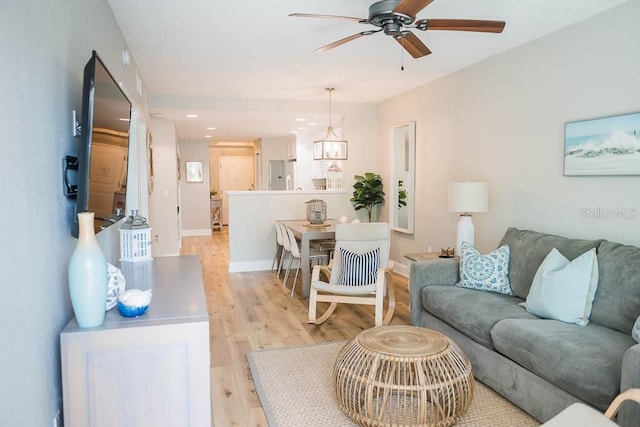 living room with light wood-type flooring and ceiling fan