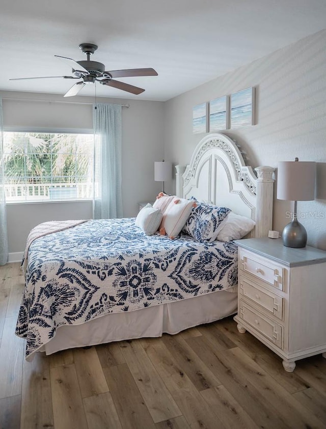 bedroom with multiple windows, light hardwood / wood-style floors, and ceiling fan