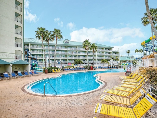 view of pool with a water slide and a patio area