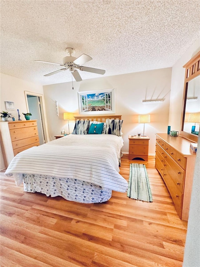 bedroom with a textured ceiling, light hardwood / wood-style flooring, and ceiling fan