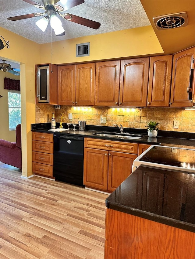 kitchen with dishwasher, sink, light hardwood / wood-style flooring, a textured ceiling, and decorative backsplash