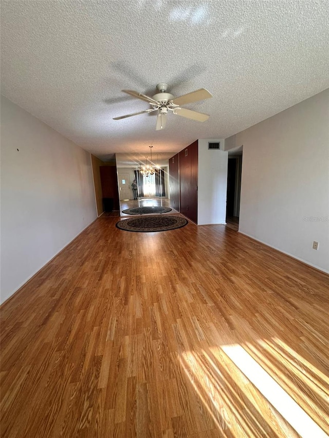 unfurnished living room with a textured ceiling, light hardwood / wood-style floors, and ceiling fan