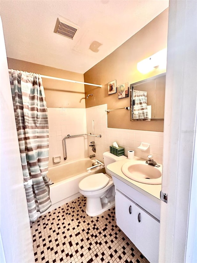 full bathroom featuring vanity, tile patterned flooring, toilet, tile walls, and shower / tub combo with curtain