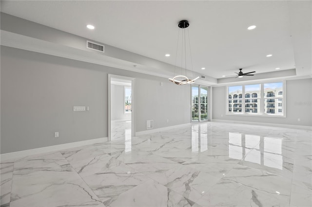 tiled spare room with ceiling fan and a tray ceiling