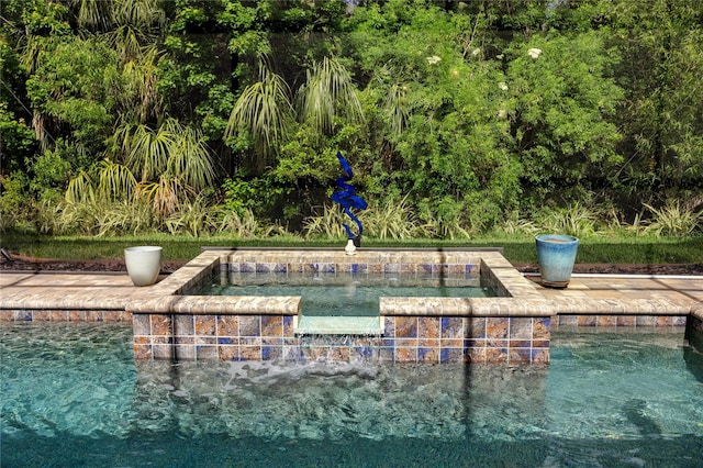 view of pool with pool water feature and a hot tub