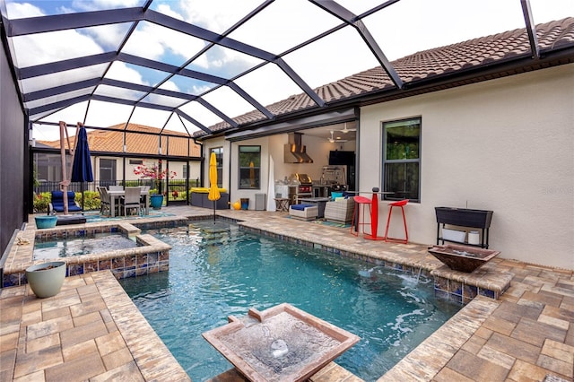 view of pool with glass enclosure, an in ground hot tub, a patio, ceiling fan, and pool water feature